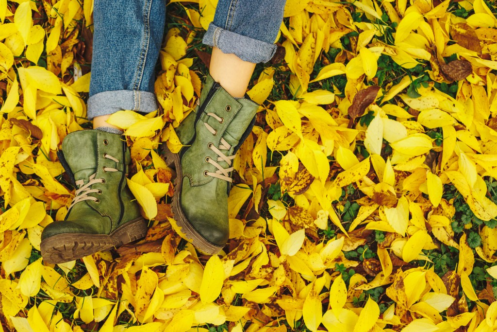 Feet with shoes on autumn leaves