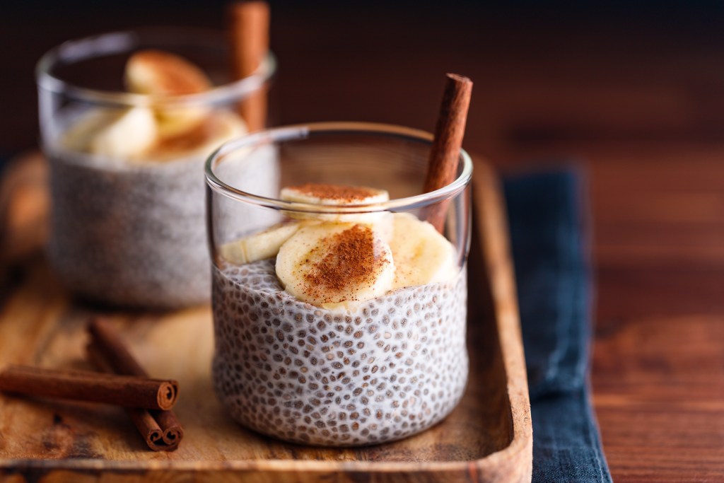 Food For Mood 2: Healthy vegetarian snack: Chia pudding with coconut milk and banana in glasses on a table
