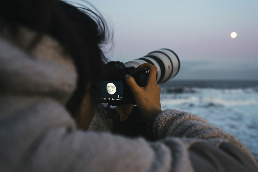 Woman going from "I'm bored" to capturing the moon by the sea