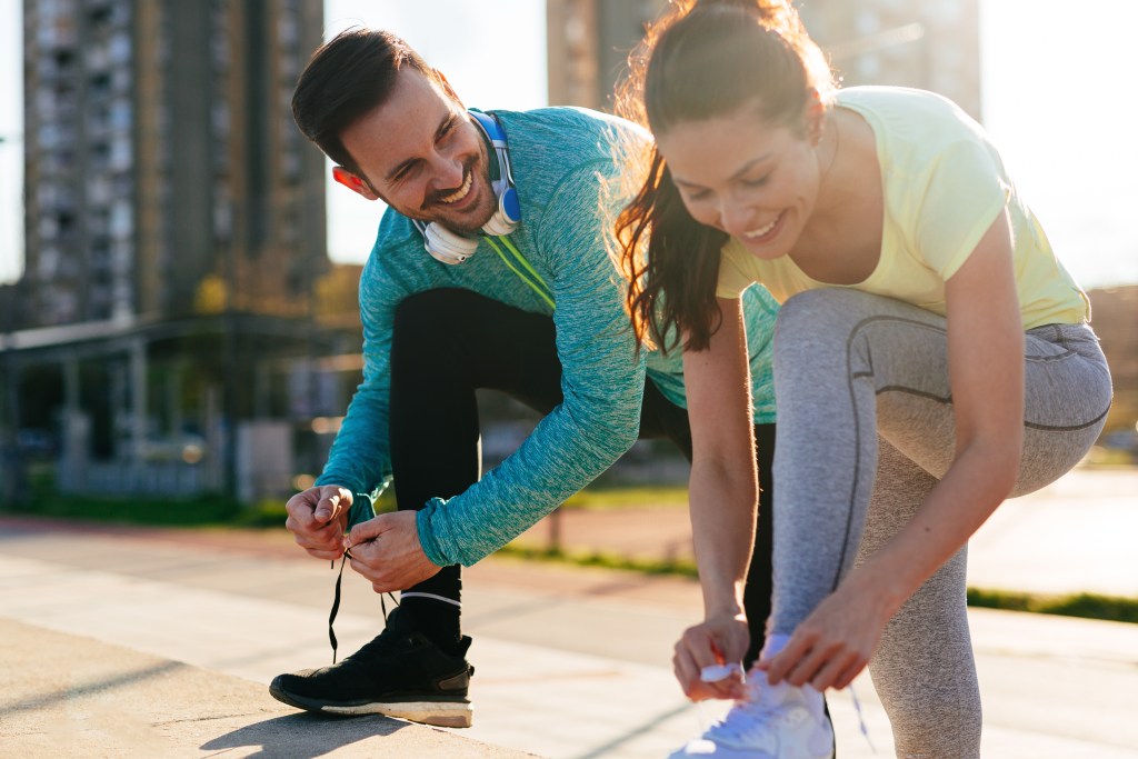 Two friends tying their running shoes and getting ready for a light run