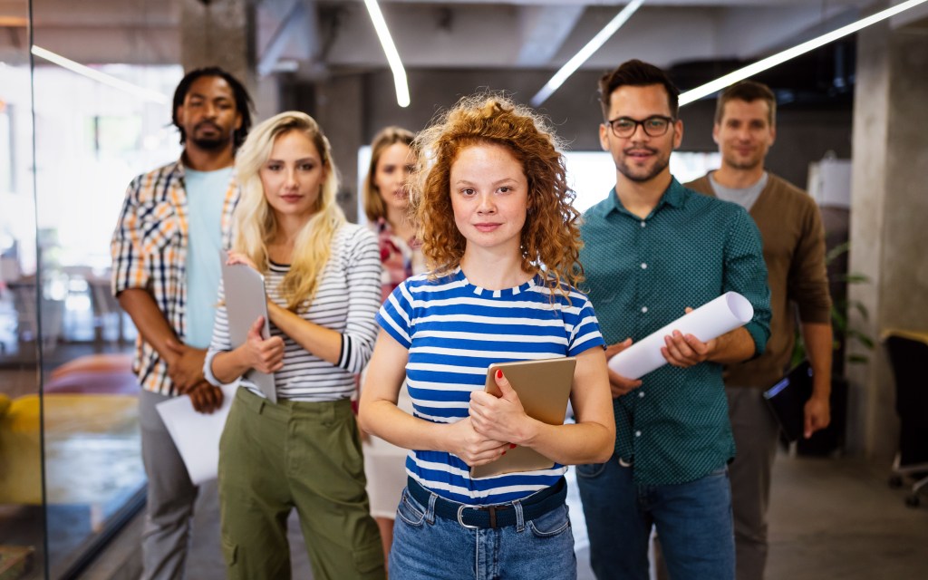 Group of five young professionals empowered by emotional and psychological readiness in their workplace. They are ready and equipped to tackle any challenge ahead.