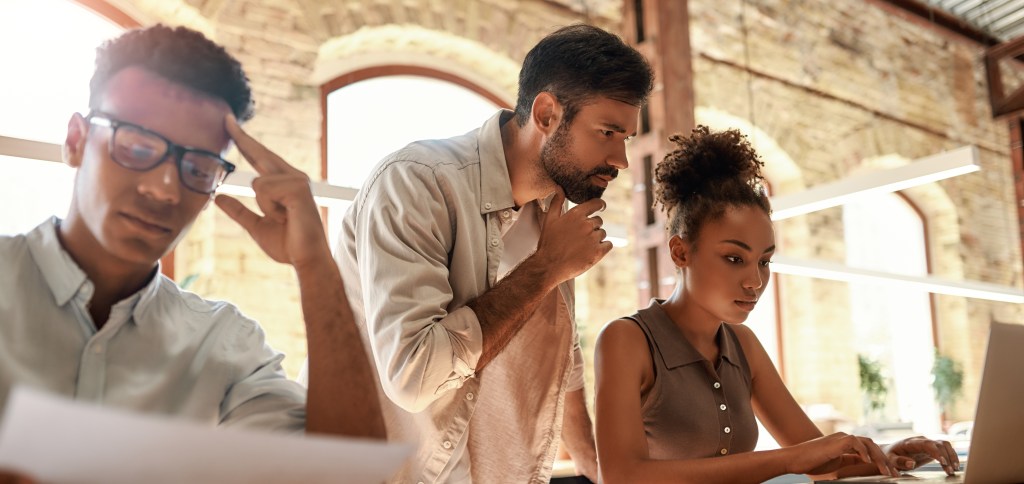 Supervisor helping young woman and man to push themselves for performance, while also providing support, guidelines and permission to switch off and recover. 