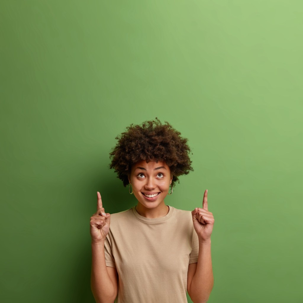 Cheerful woman gets that her statistics empower her. She points both index fingers upwards to show she got the main message of snackable content #4.