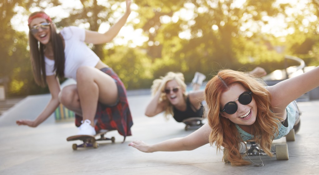 Three young women exploring skating in the skate park, having fun, doing activities outside of the relationship and creating room for own needs.