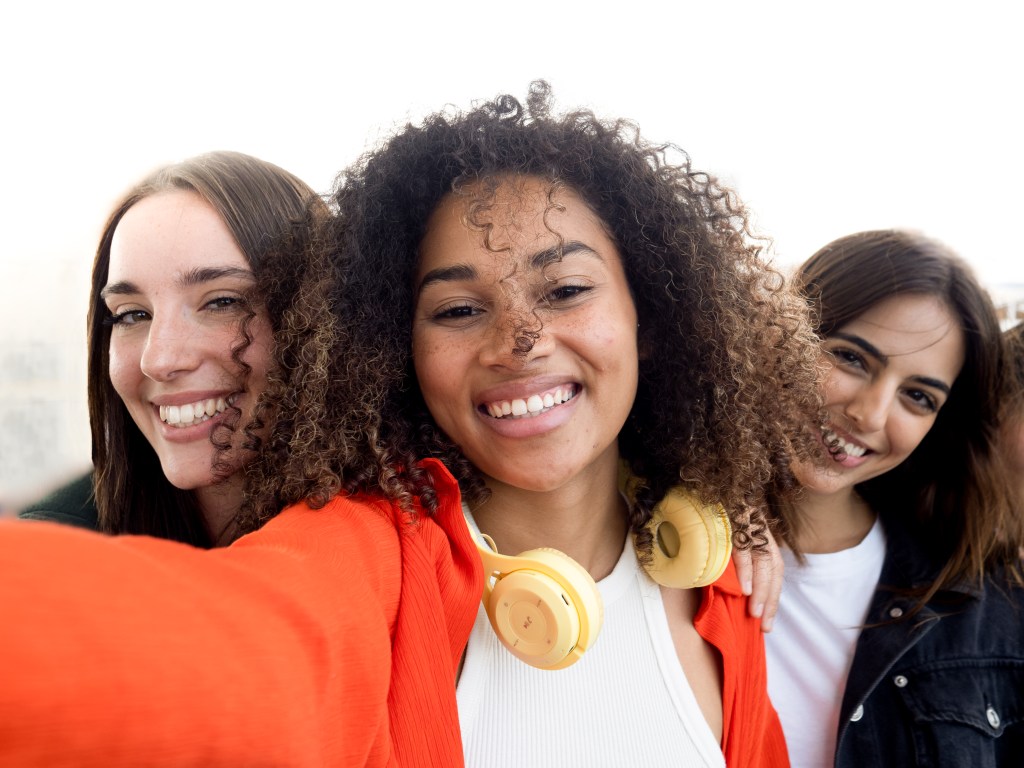 Let go: Three young female friends looking confident and having fun after a break up, taking selfie