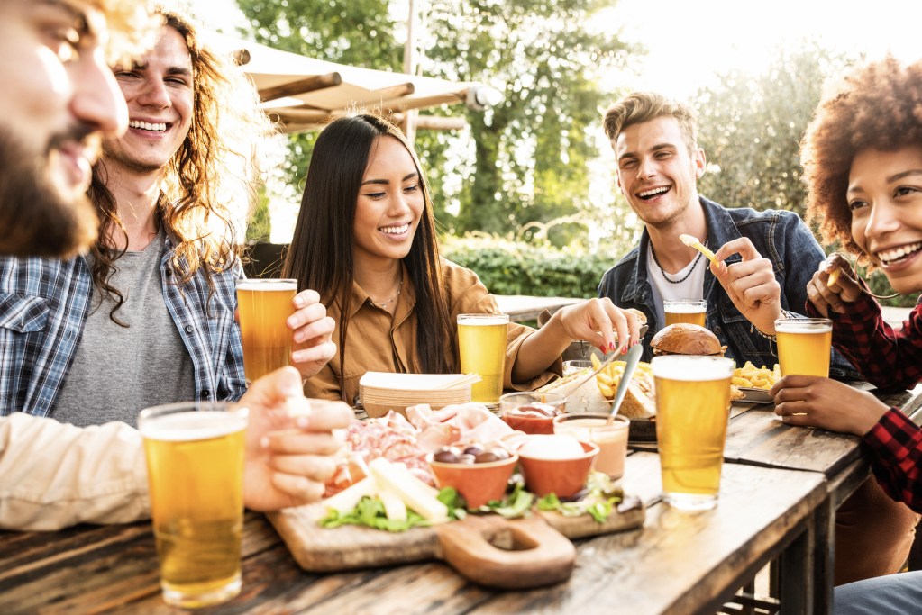 AI companions nudge towards real-life experiences: Friends having outdoor lunch