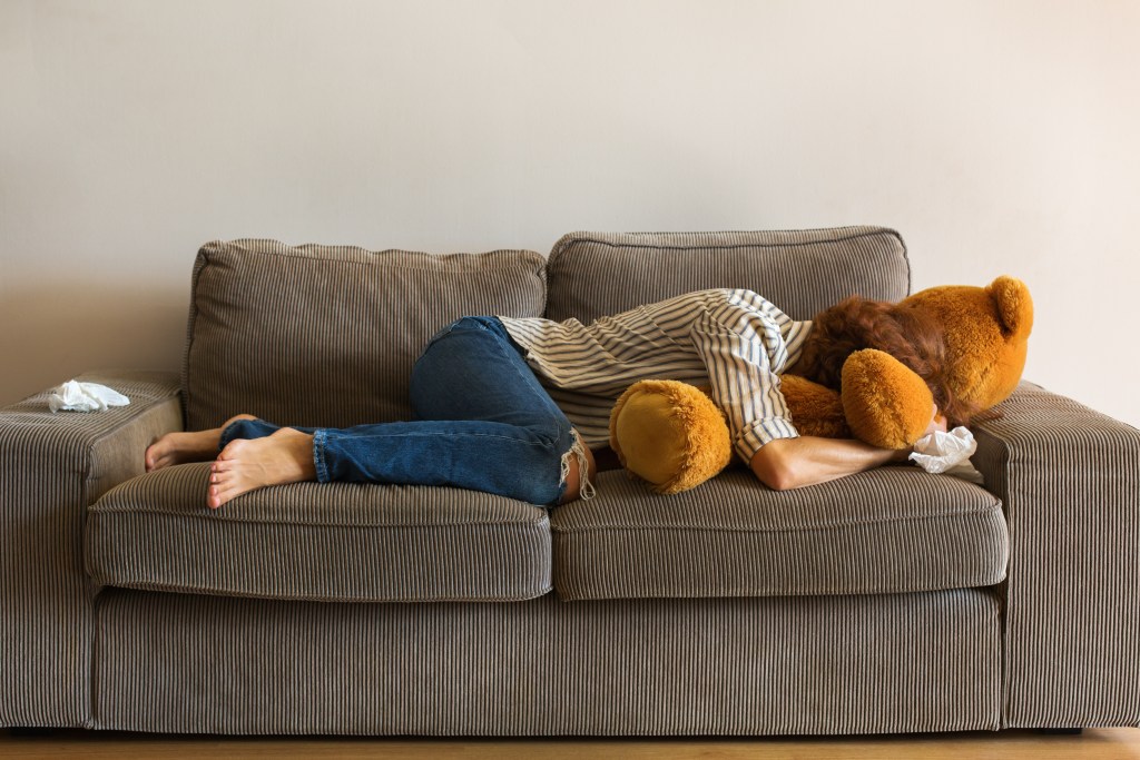 Woman lying on the sofa,  tired, sad, intrusive thoughts, no motivation to get up