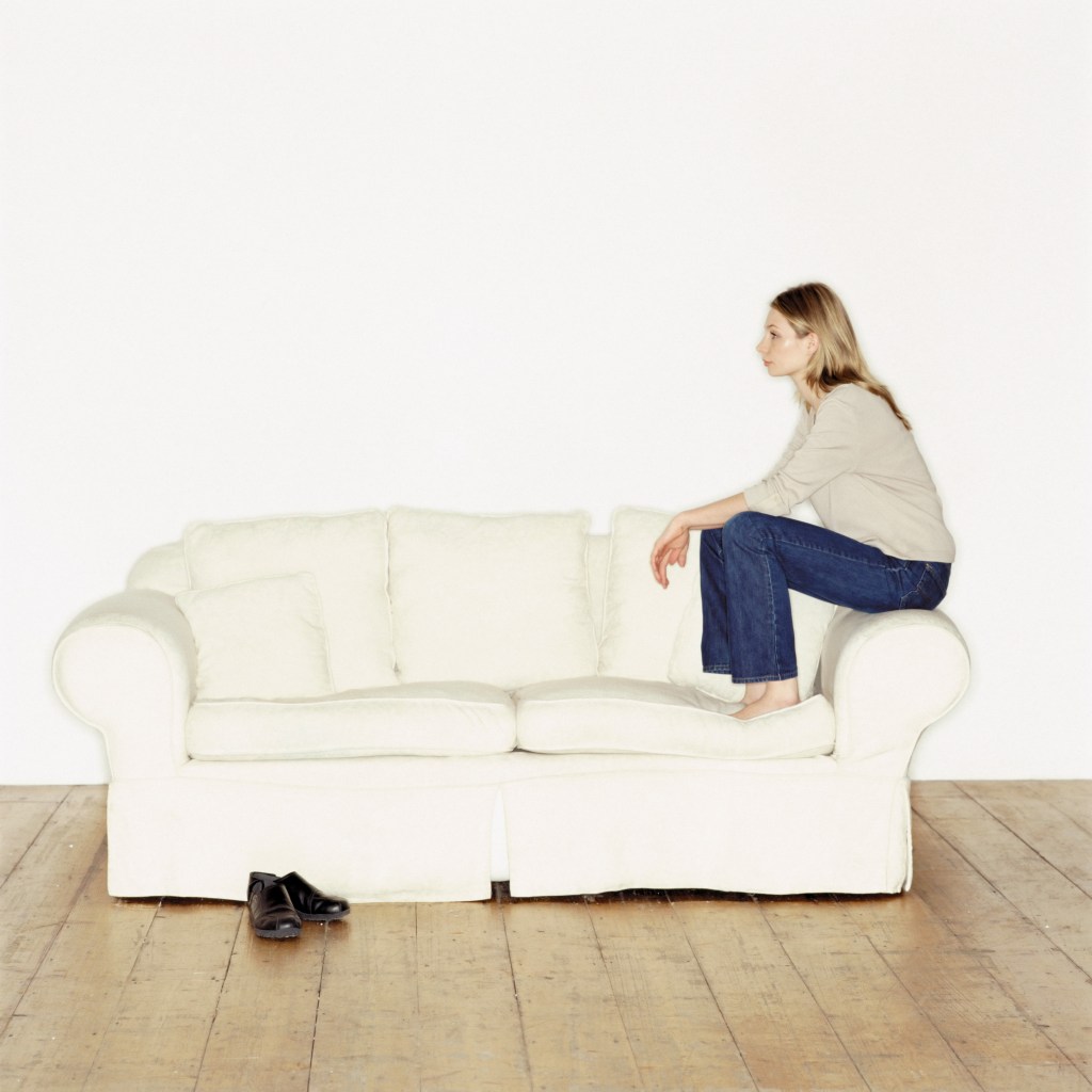 When everything feels too much: Woman simply sitting on the sofa doing nothing.
