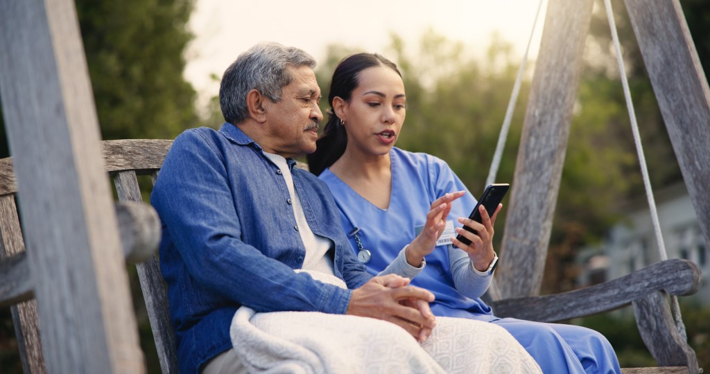 Accessibility solutions can make all the difference in mental health support: Nurse explaining several app-based accessibility solutions to male patient in wheelchair.