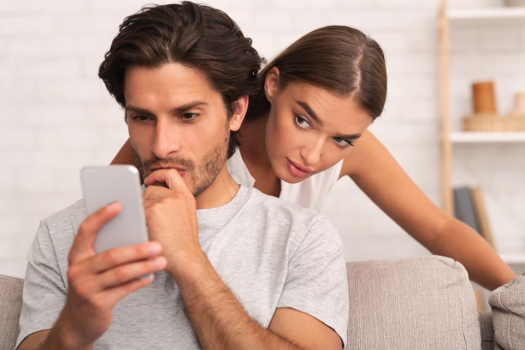 Types of jealousy: Wife spying on husband while he's texting on phone 