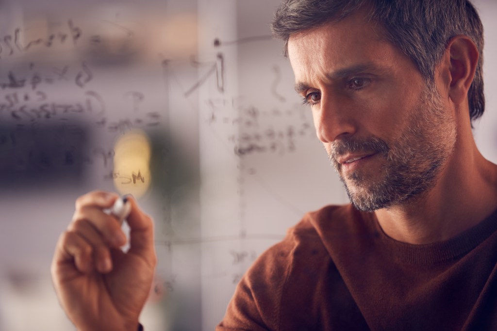 Is Intuition the Highest Form of Intelligence? Brainstorming businessman drawing graph calculation on glass screen