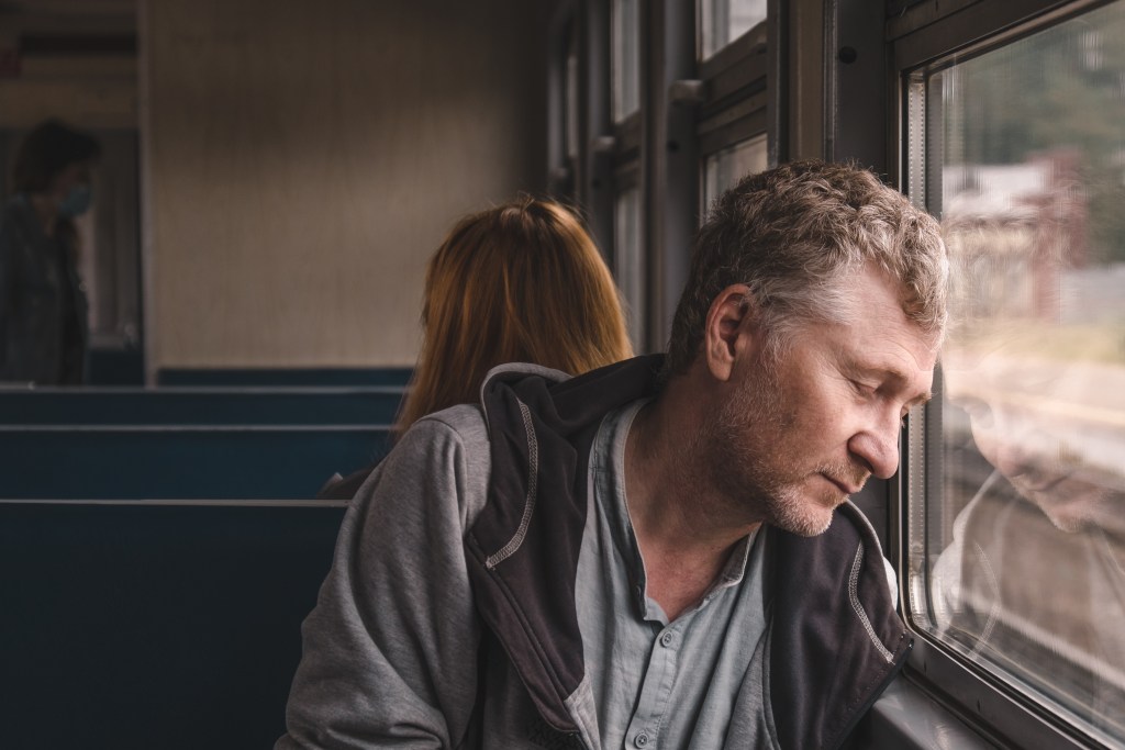 Healing from trauma quotes: Man suffers from unsolvable problems while sitting at window on public transport