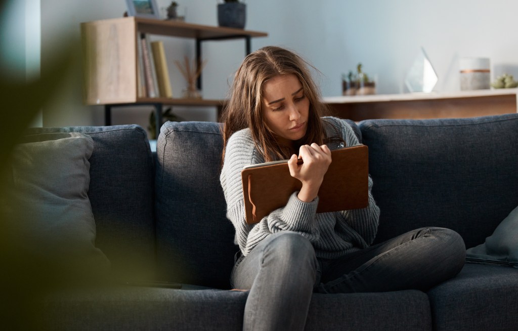 Anxious young woman writing in her journal to stop worrying about things she can't control