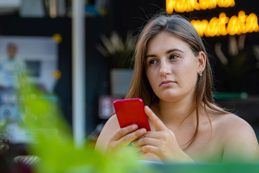 Woman experiencing friendship anxiety as she's not getting an answer on her phone
