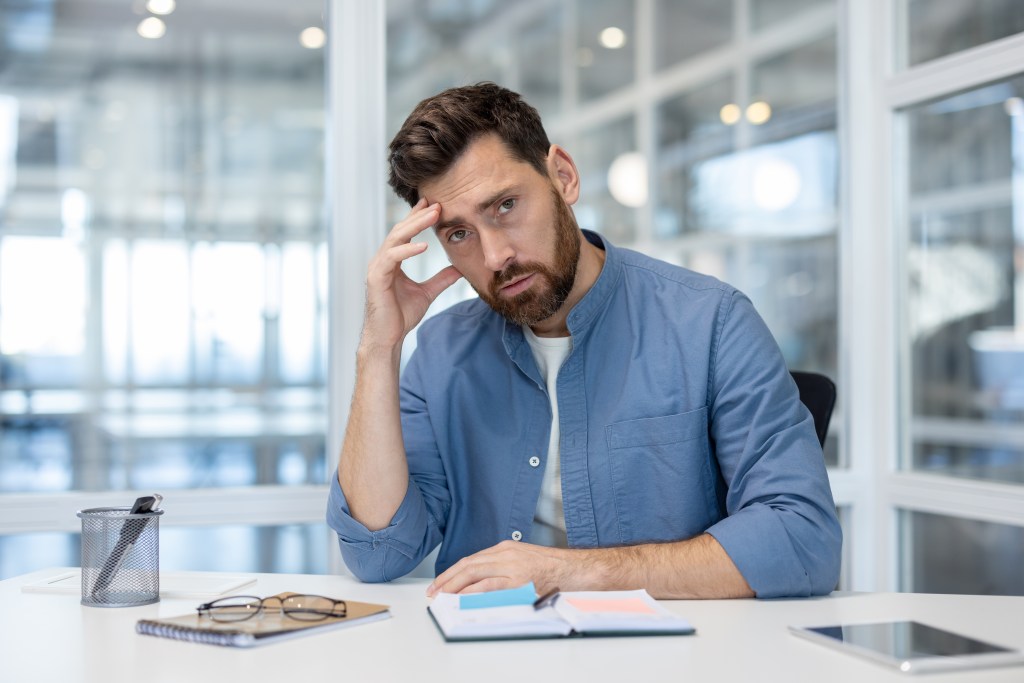 Frustrated, disappointed and quietly cracking employee looking tired