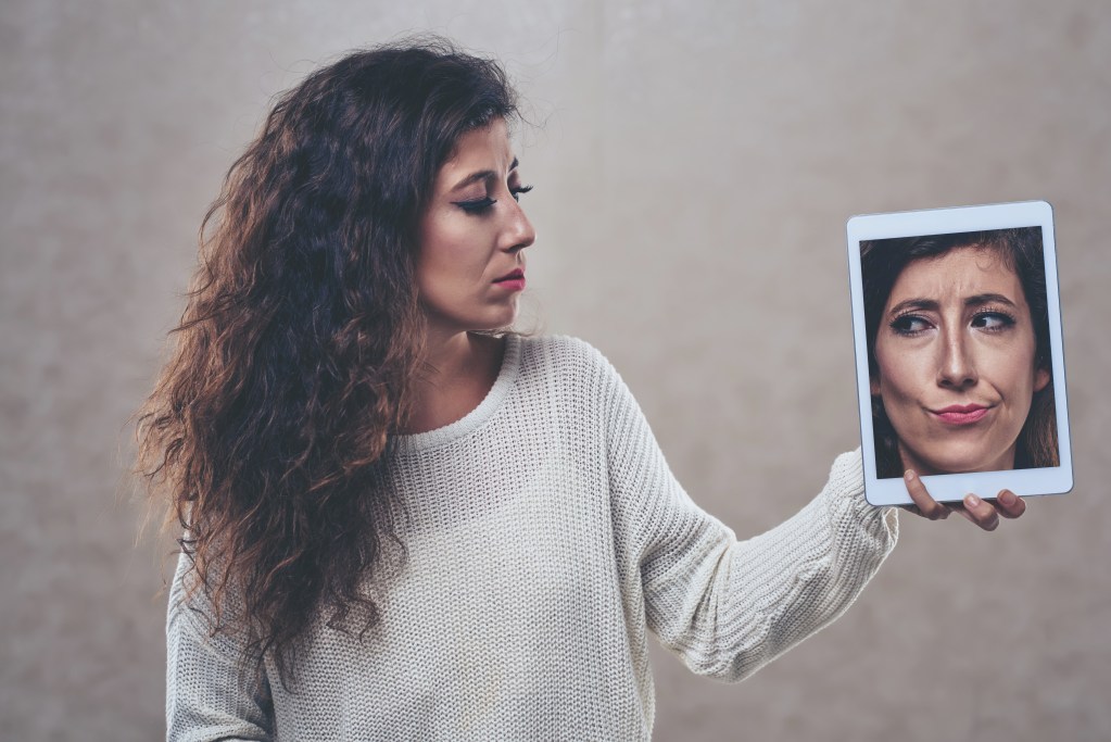 Woman looking at her photo on digital tablet: Is an AI boyfriend safe?