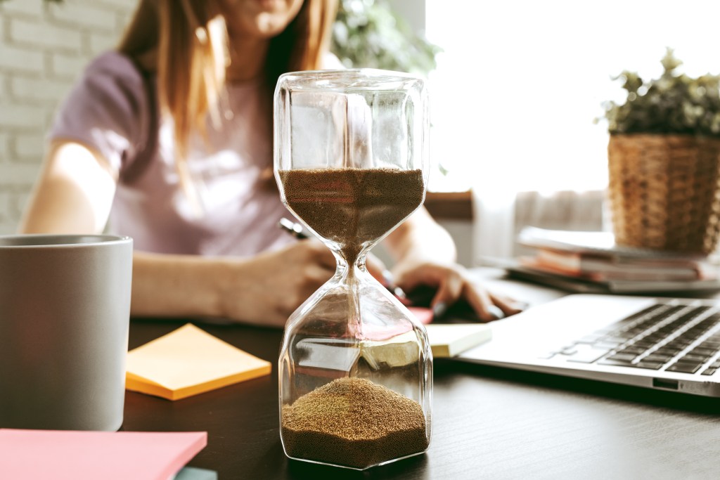 Student outsmarting academic stress by timing well with hourglass