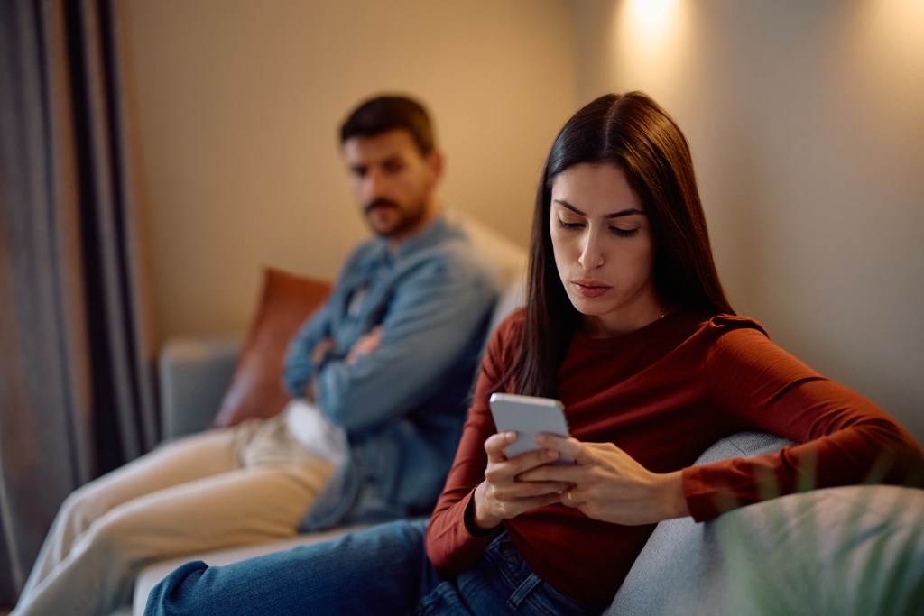 AI relationships can develop in rough times: frustrated woman chatting while husband is upset