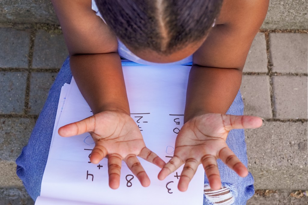 Girl learning to confront math anxiety by counting her fingers
