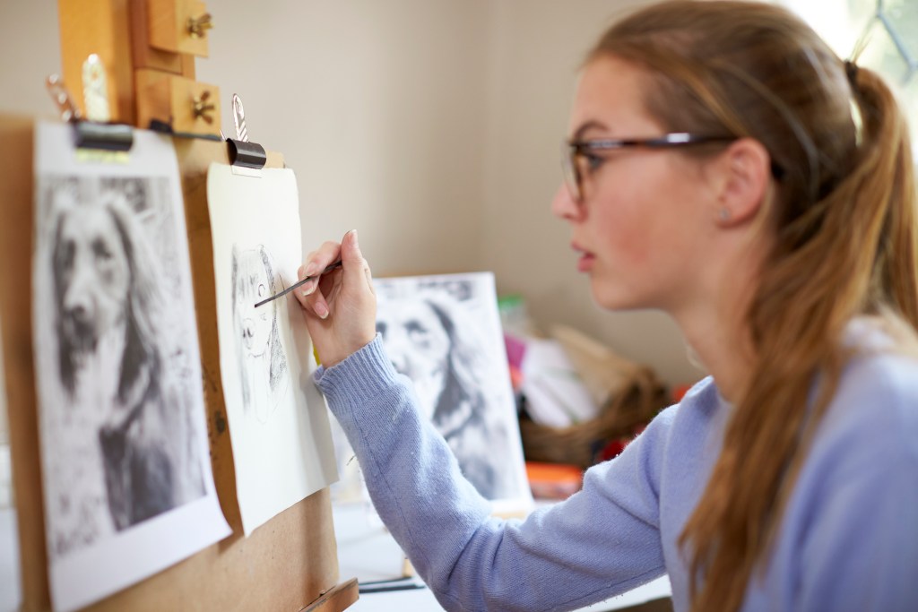 Teenager overcoming her fear of dogs by drawing a dog on her canvas