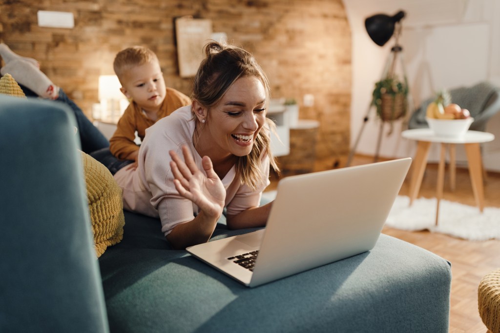 Mother with toddler engaging with digital tools to improve her mental health from comfort of her couch.