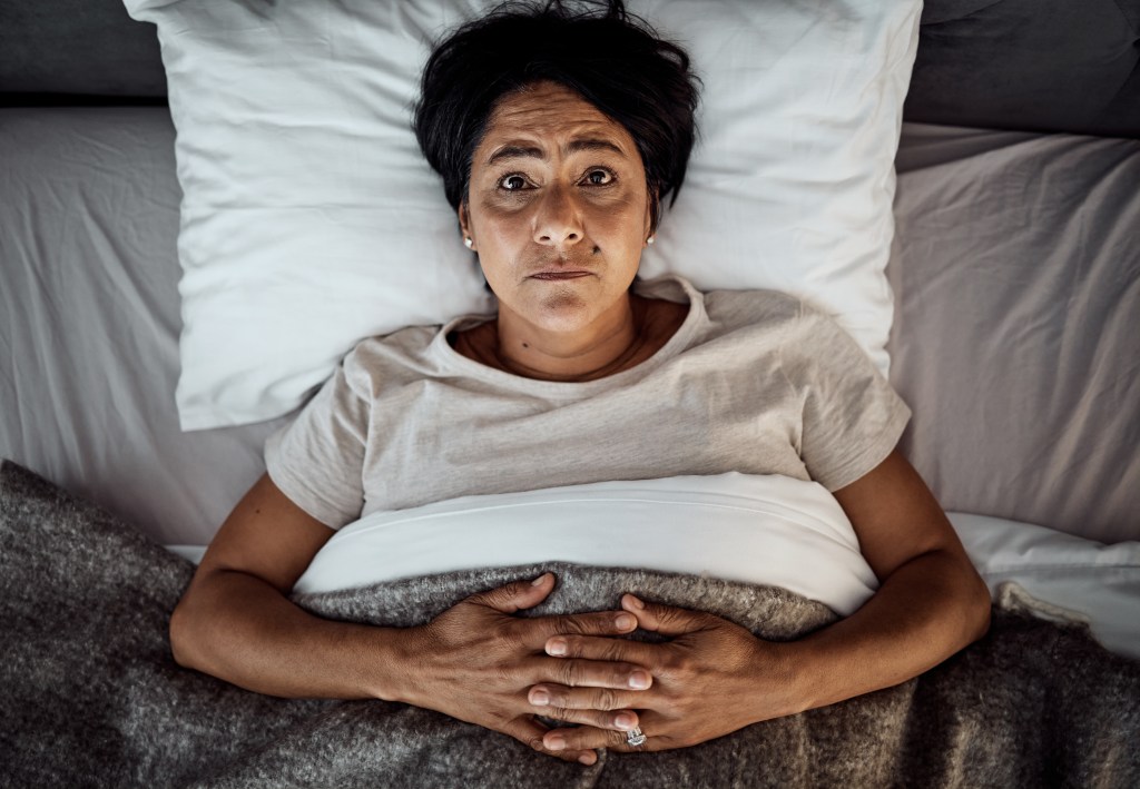 Woman Lying in Bed with Concerned Expression